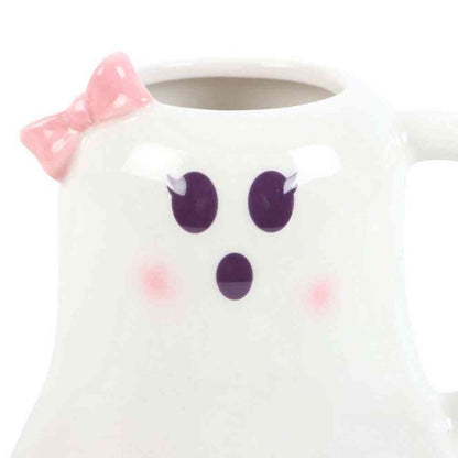 Ghost-shaped mug close-up: pink bow, purple eyes and nose on white ceramic