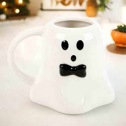 Ghost-shaped ceramic mug, white with black dot eyes and bow smile