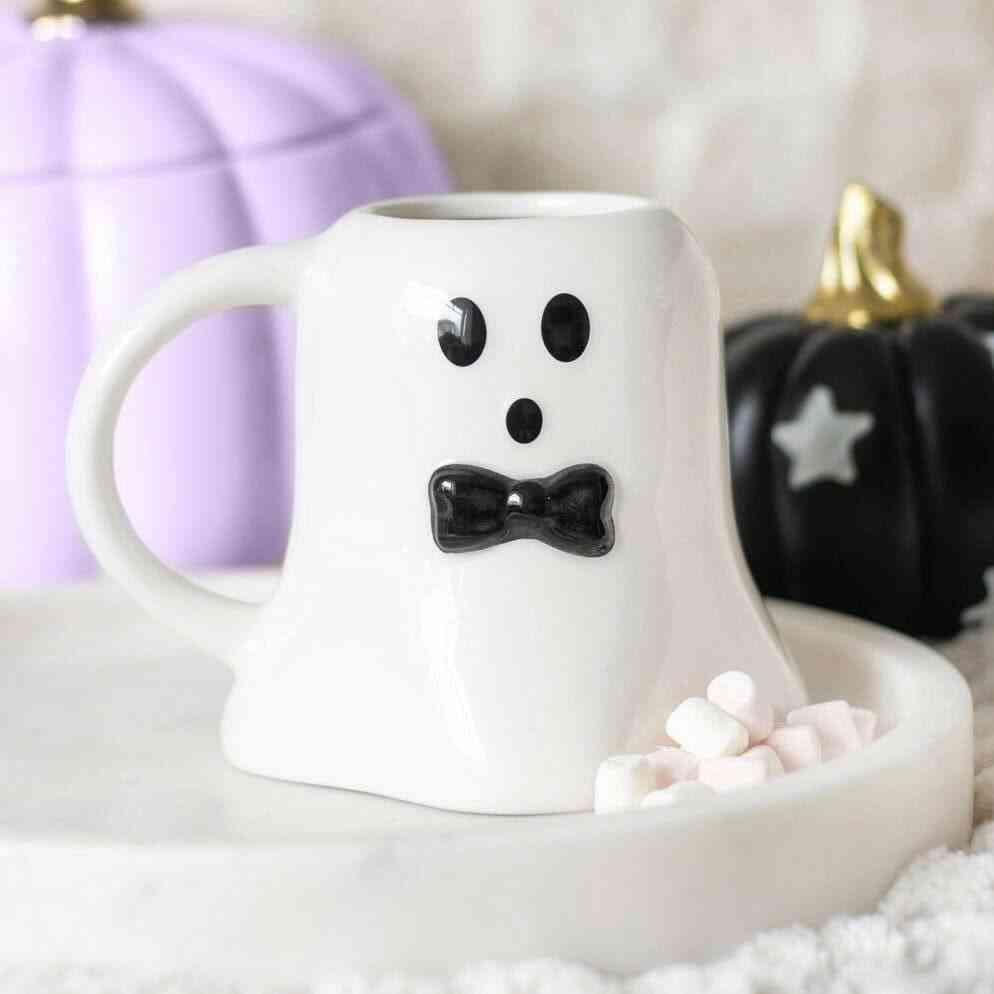 Ghost-shaped mug with black eyes and bow tie, white ceramic, side view