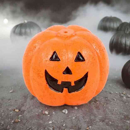 Orange pumpkin incense stick holder with black jack-o'-lantern grin