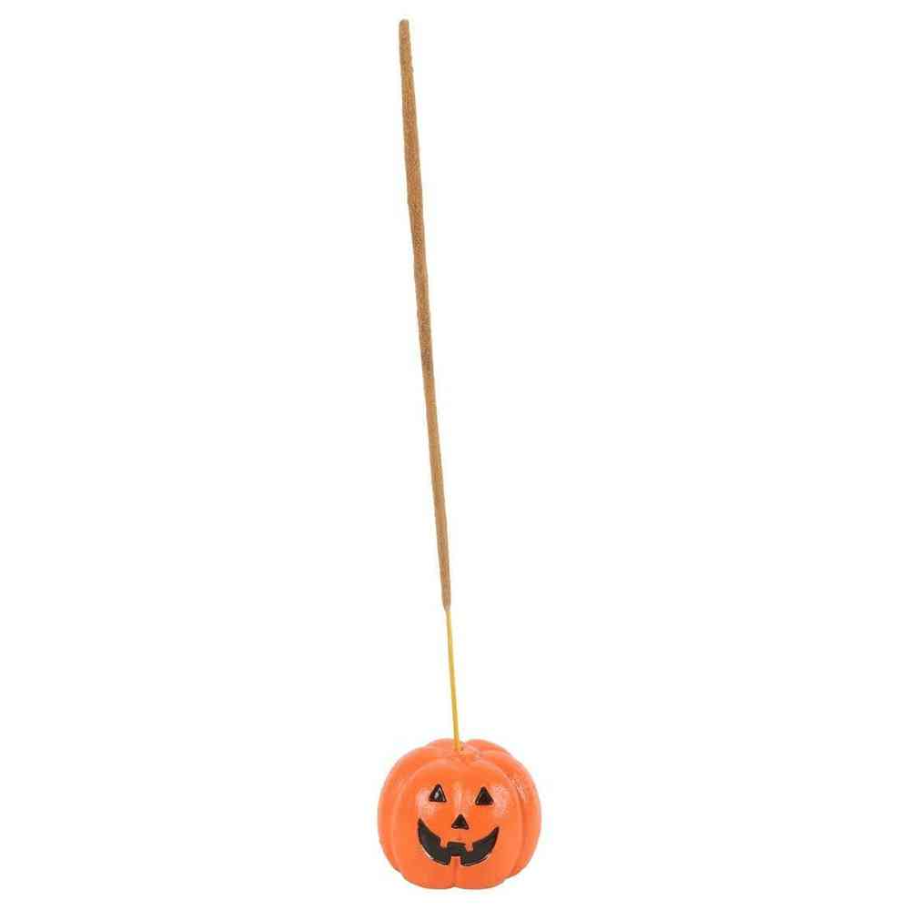 Orange pumpkin incense stick holder at end of incense stick