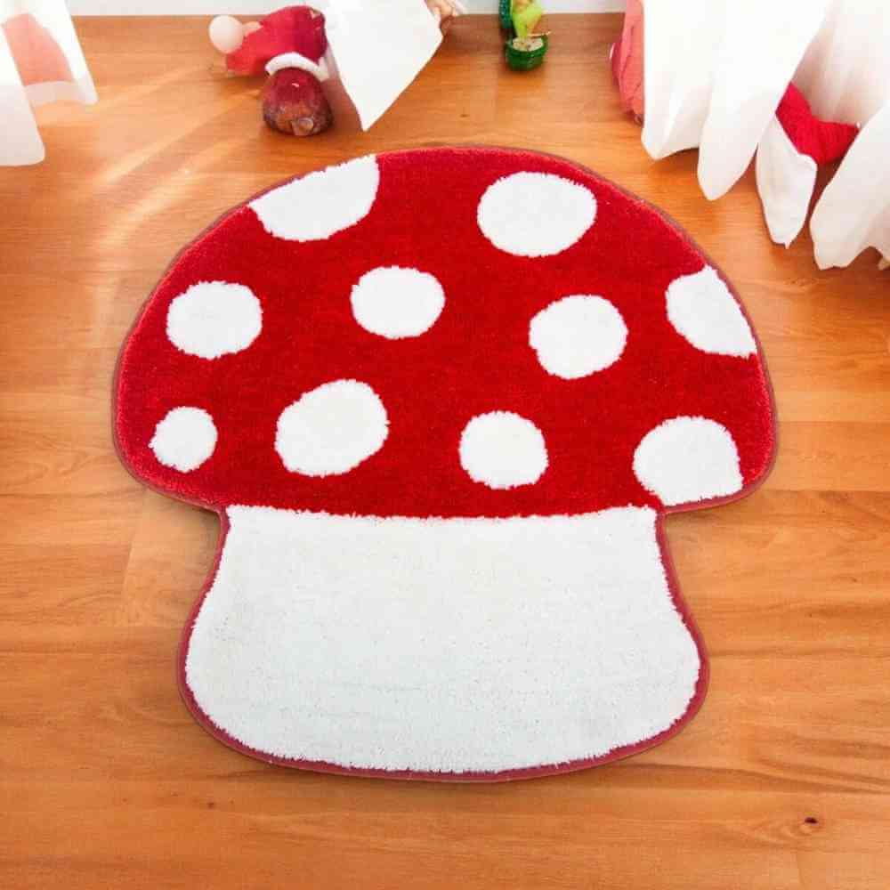 Red mushroom bathroom mat with white polka-dot cap and tufted white stem, on the floor