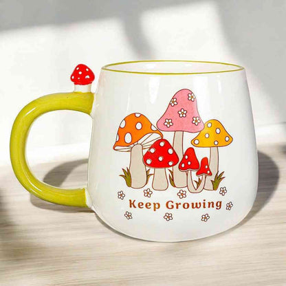 Garden mushroom mug, side view: white cup with green handle and colorful mushroom 'Keep Growing' print