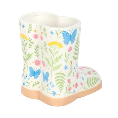 Floral welly boot planter with blue butterfly and wildflower print, ceramic plant pot on a white background.