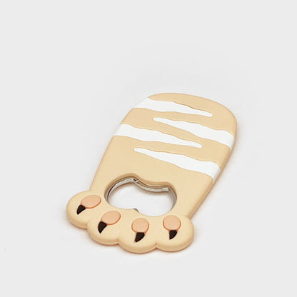Cat bottle opener magnet close-up with a round bottle-cap opening and three paw pads.