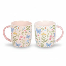 Pair of floral print ceramic mugs, white with colorful leaves and butterflies, pink handles