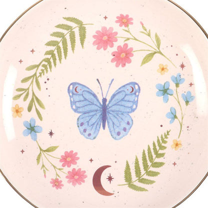 Close-up butterfly trinket dish with pink and green floral border, moon detail