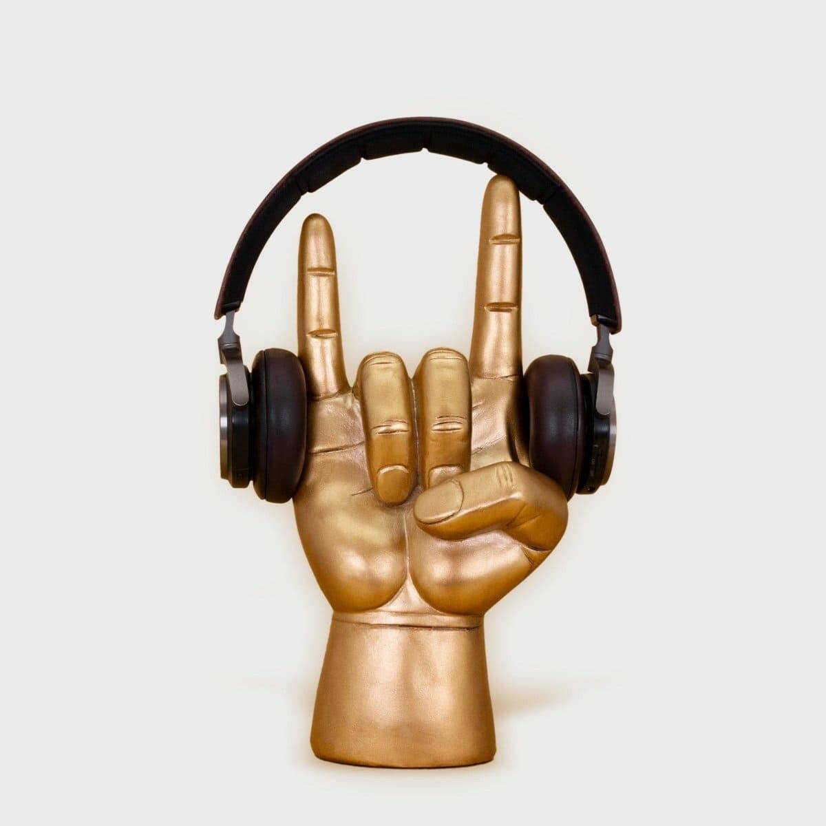 Rock On headphone stand with golden hand and black over-ear headphones