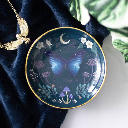 Round trinket dish with blue moth, moon, floral accents, and gold rim
