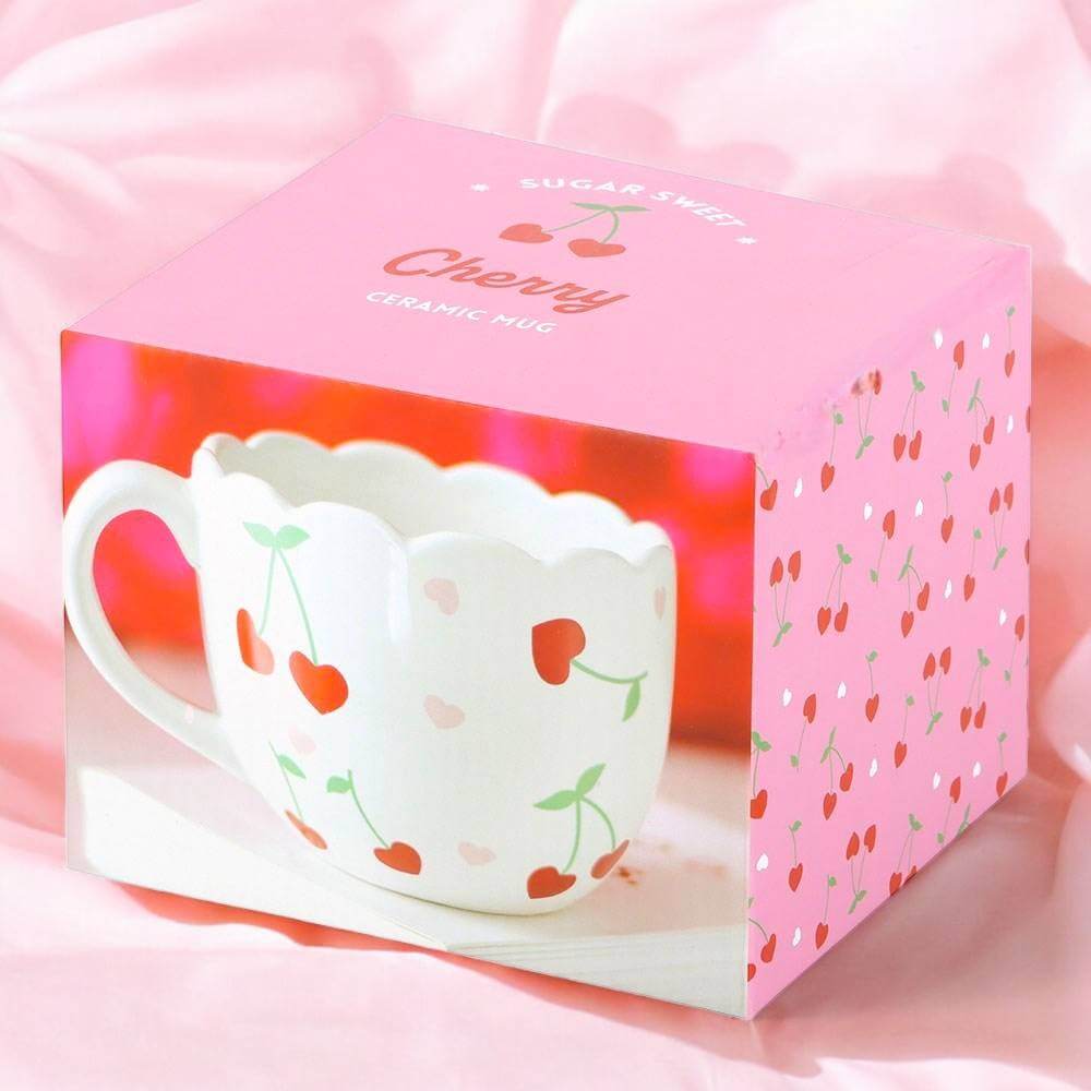 White scalloped mug with heart and cherry stem print, shown in a pink gift box
