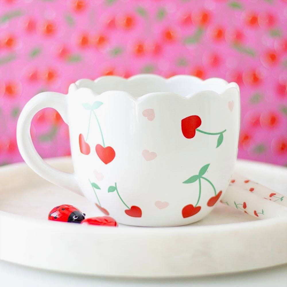 White scalloped mug with red and pink hearts and green cherry stem pattern