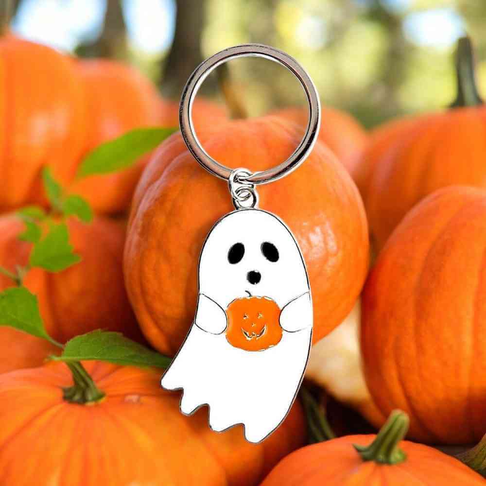 White ghost charm keychain on silver ring holding orange pumpkin-shaped heart