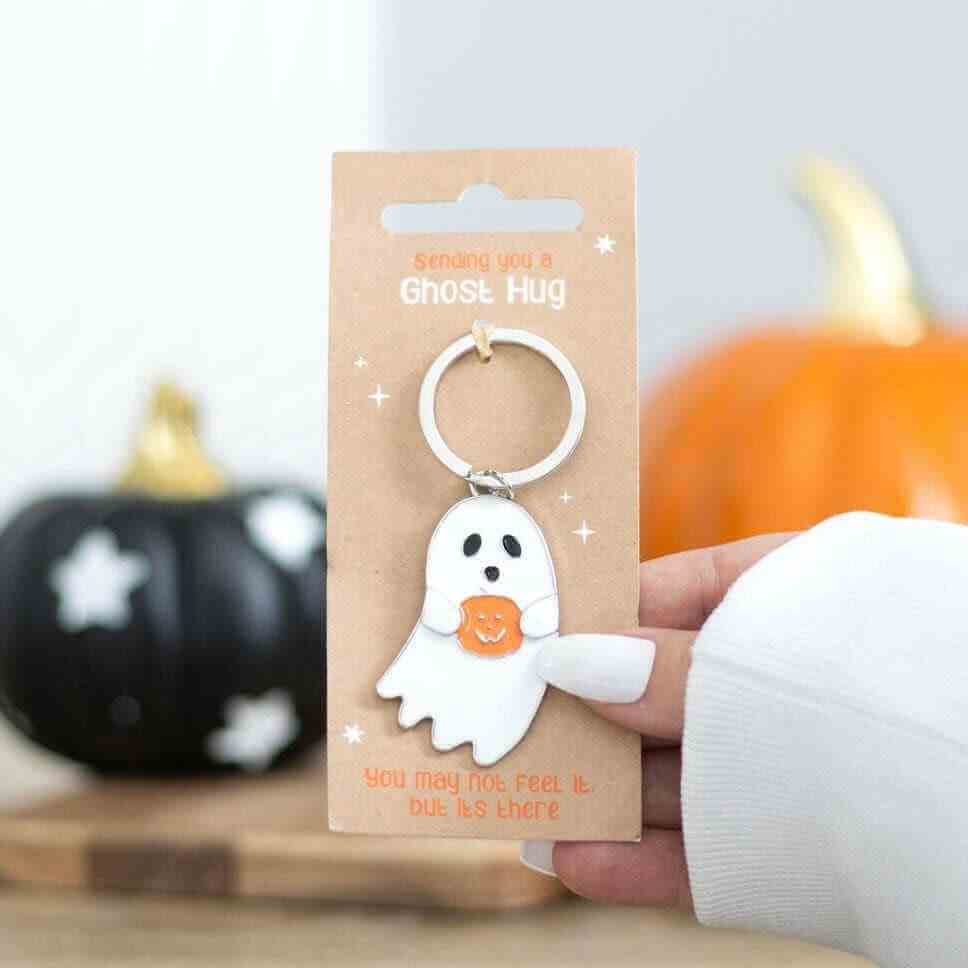 Ghost hug keyring with white ghost charm holding orange pumpkin-shaped heart