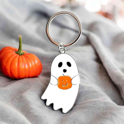 Silver keyring with white ghost charm holding orange pumpkin-shaped heart