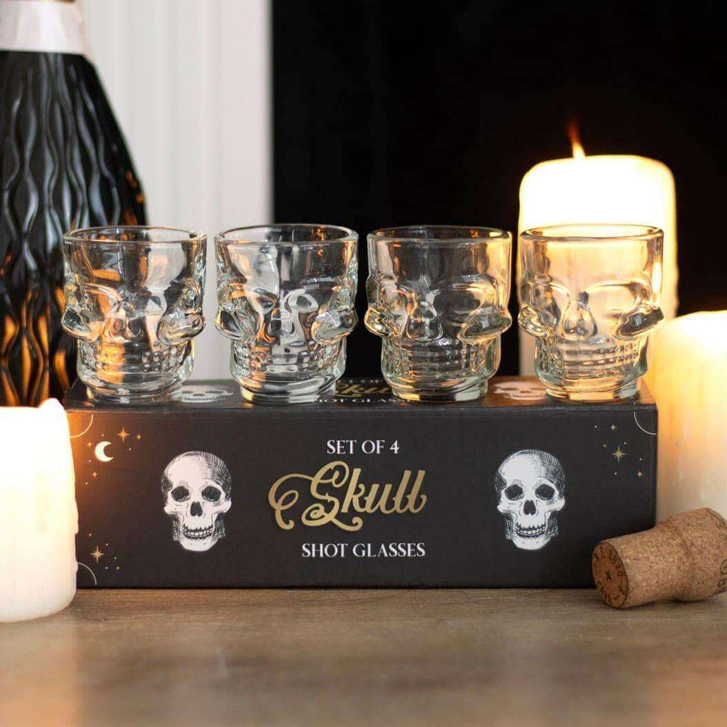 Set of 4 clear skull shot glasses on box with skull face designs
