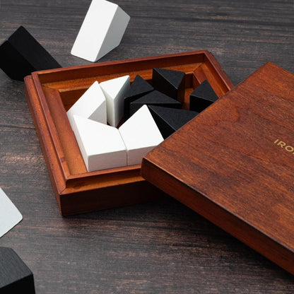 Wooden puzzle tray with white and dark block pieces and hinged lid