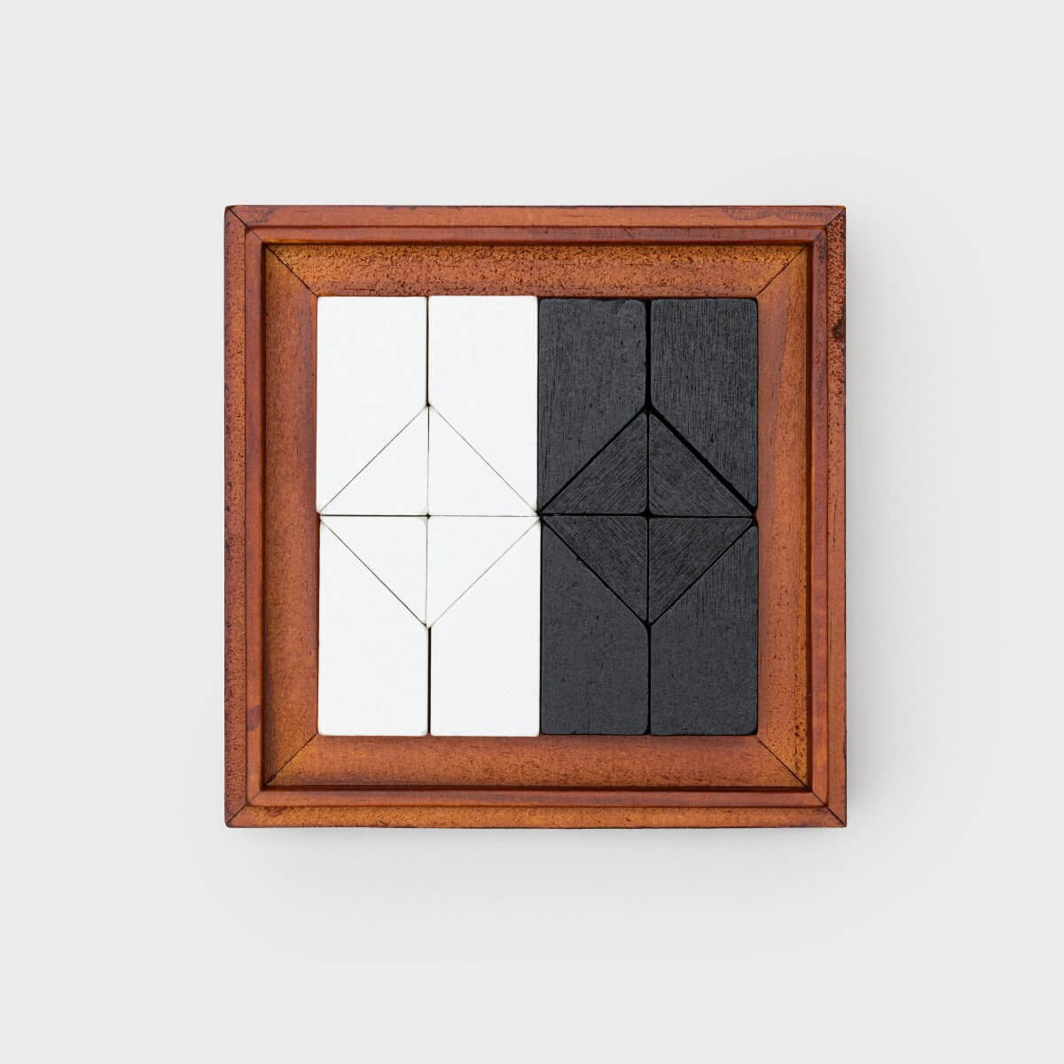 Square wooden puzzle frame with white and dark tangram pieces