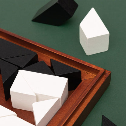 Wooden tangram tray with white and dark 3D puzzle blocks