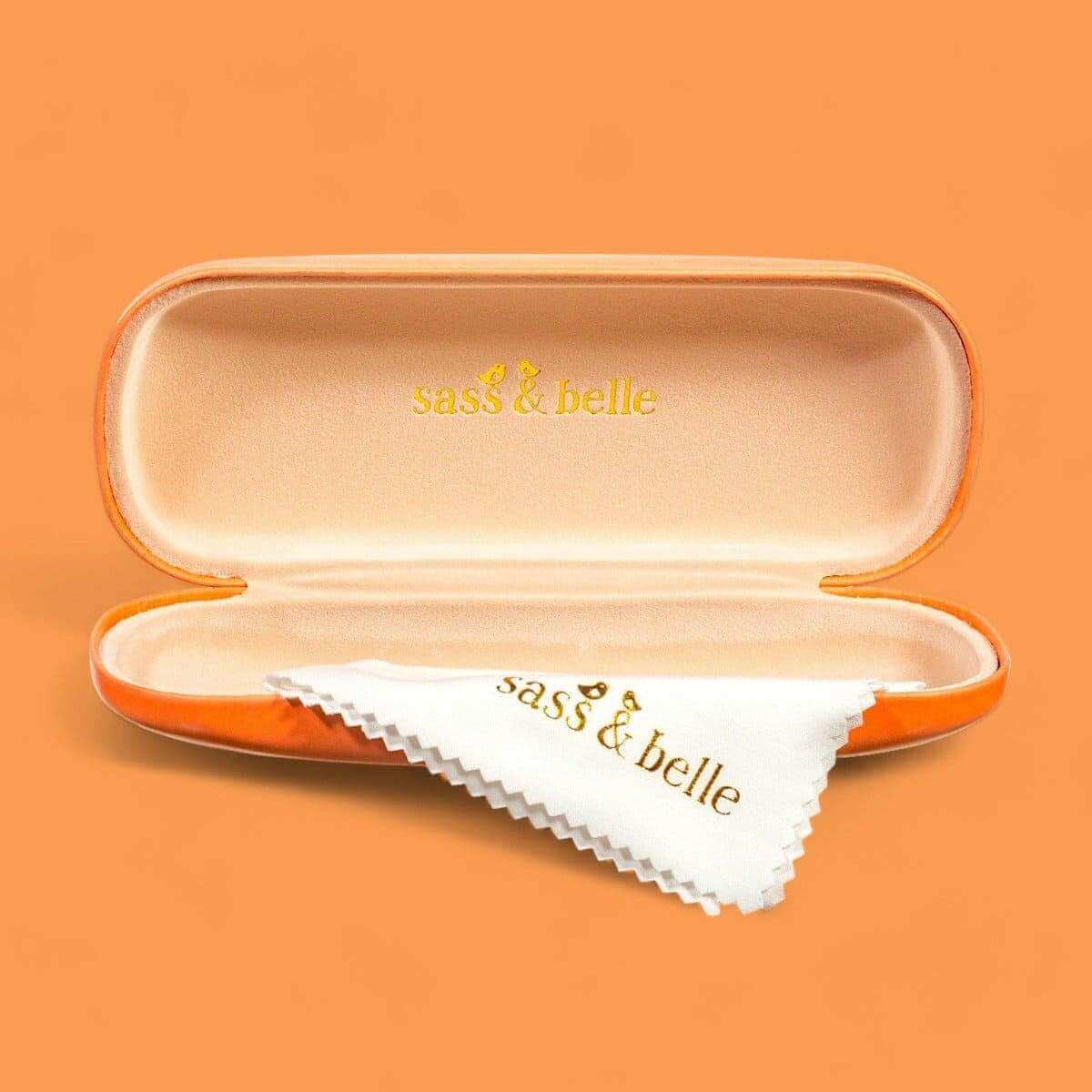 Orange eyeglasses case open, showing interior lining and white cleaning cloth.