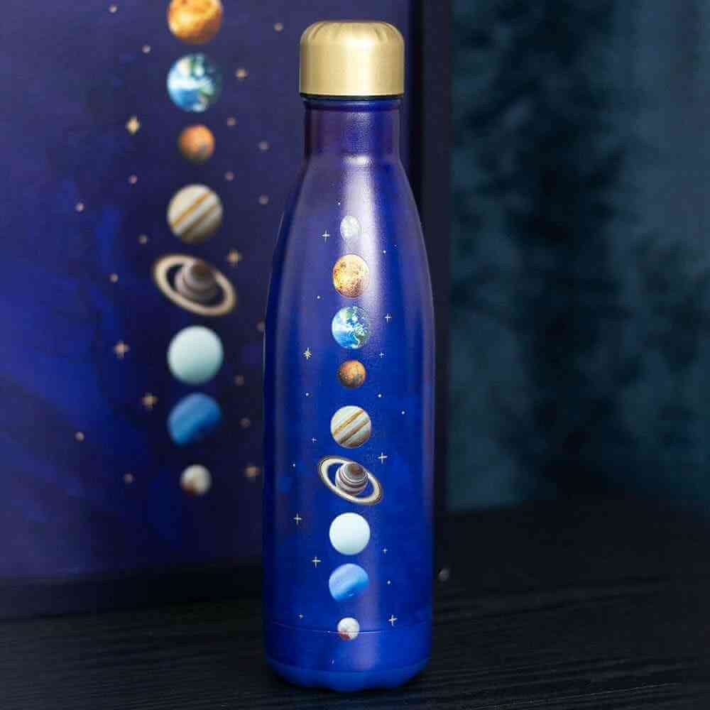 Close-up of purple metal water bottle with gold cap and solar-system planets graphic