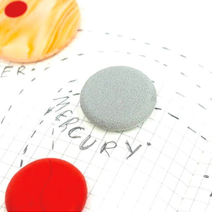 Gray round eraser and red round eraser on grid paper with dashed writing lines