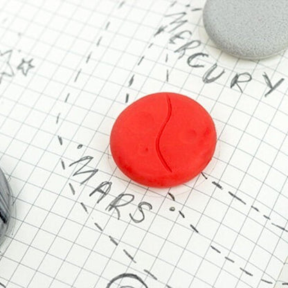 Round red planet eraser on grid paper with marker lines and dashed writing