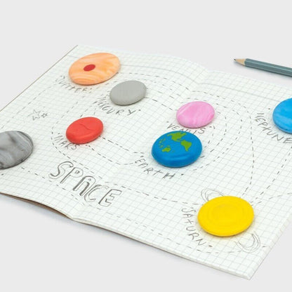 Planet-themed eraser set on graph paper: yellow, blue, pink, orange, red and gray