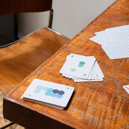 Solo Mello solitaire playing cards with card backs on a wooden table