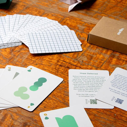 Solo Mello solitaire cards, box, and instruction sheet on wooden table