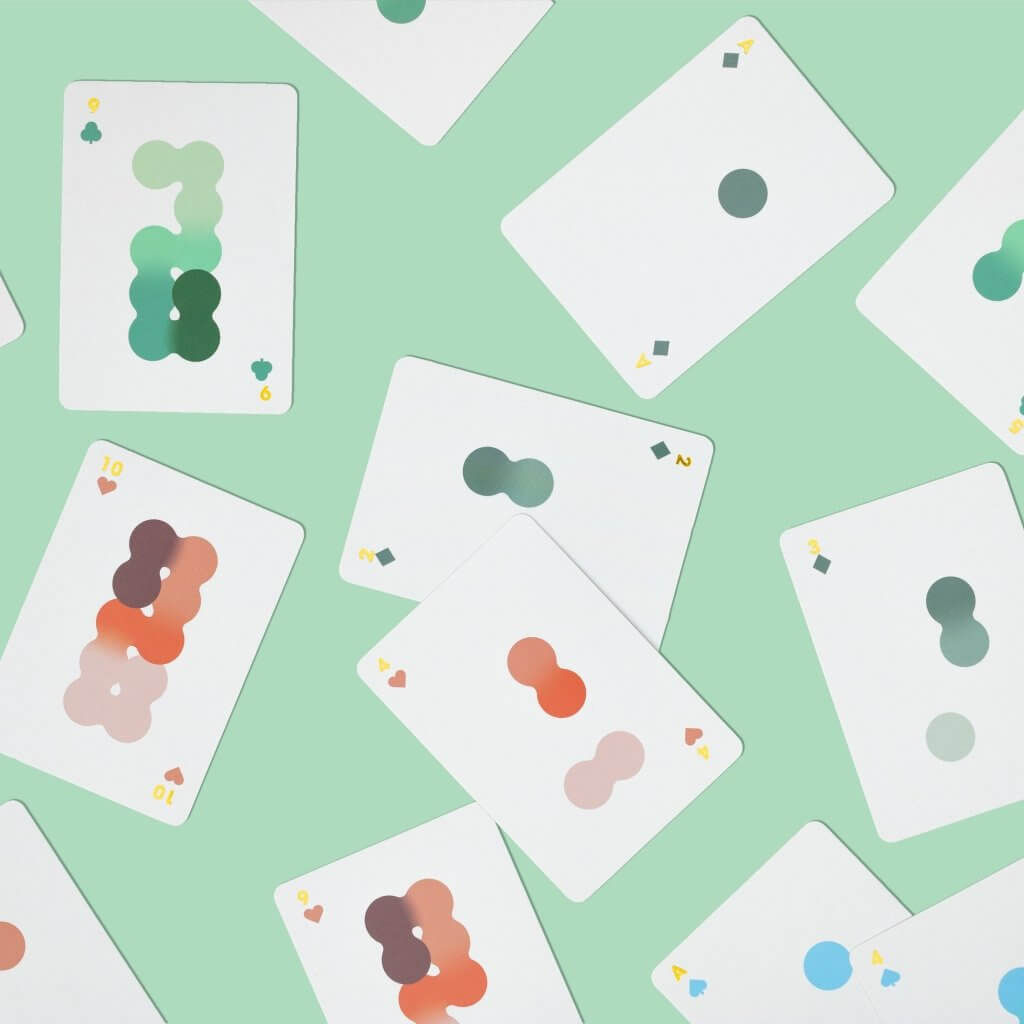 Solo Mello playing cards: scattered white cards with green, pink, and blue pips