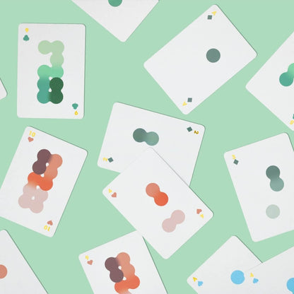 Solo Mello playing cards: scattered white cards with green, pink, and blue pips