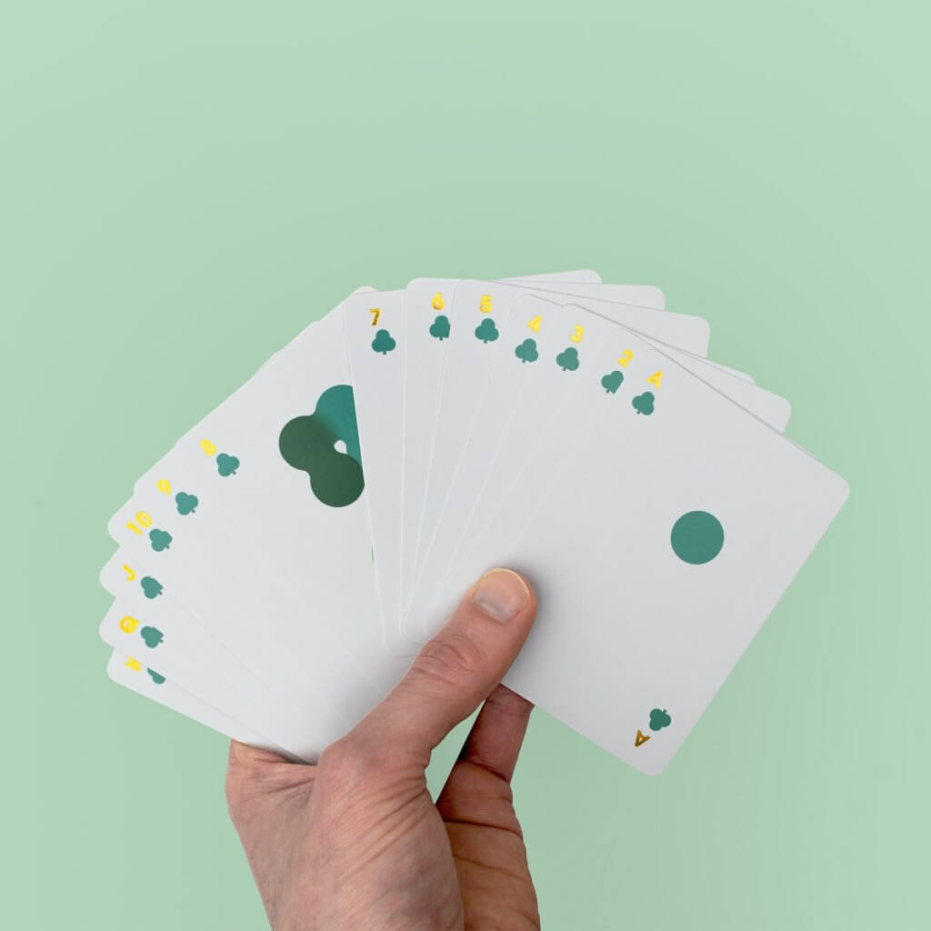 Solo Mello playing cards: fan of white cards with green and yellow clover pips