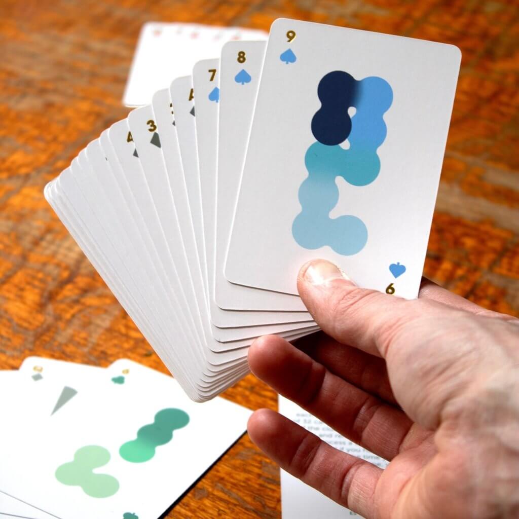 Solo Mello solitaire card fan with a hand holding blue-pattern cards