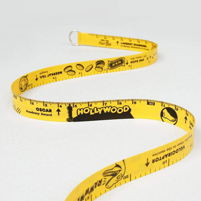 Yellow retractable tape measure with measurement markings and themed graphics