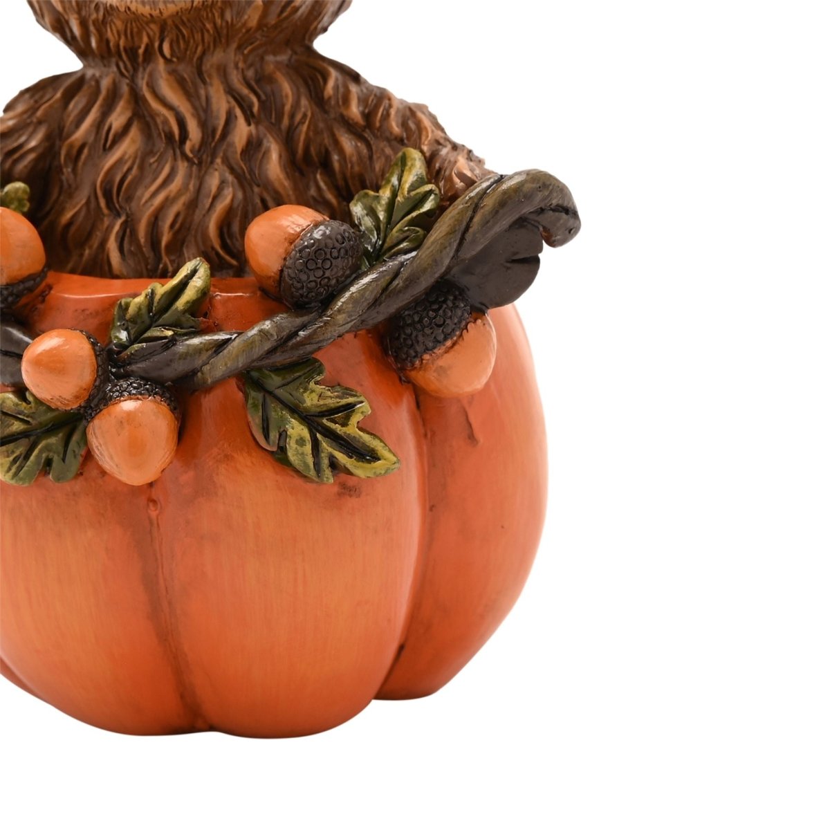 Decorative Highland cow figurine in an orange pumpkin with leaf wreath and orange fruit accents
