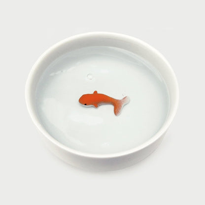 White ceramic cat water bowl with orange fish trick piece centered in water