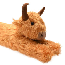 Orange plush Highland cow draught excluder close-up, horns and face, lying flat.