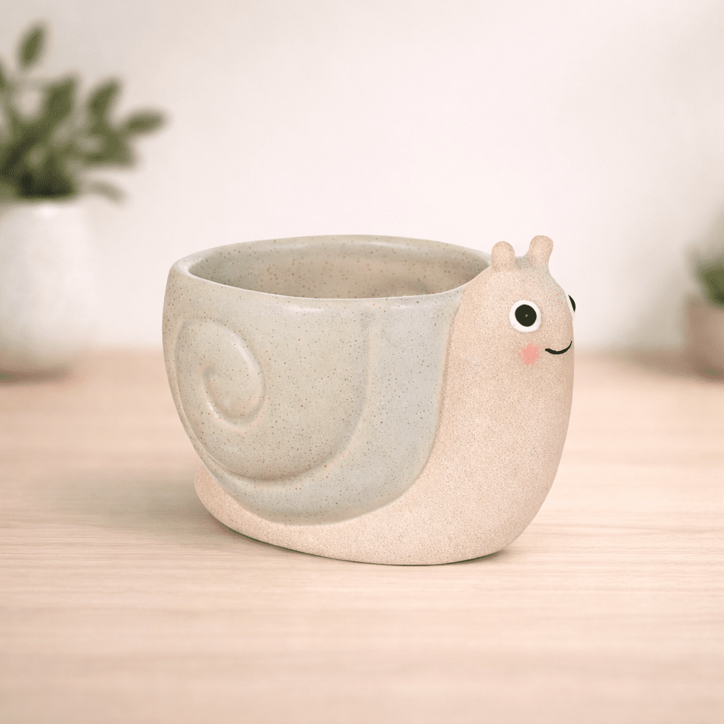 Mini snail planter, beige ceramic pot with snail face on the side; no plant visible.