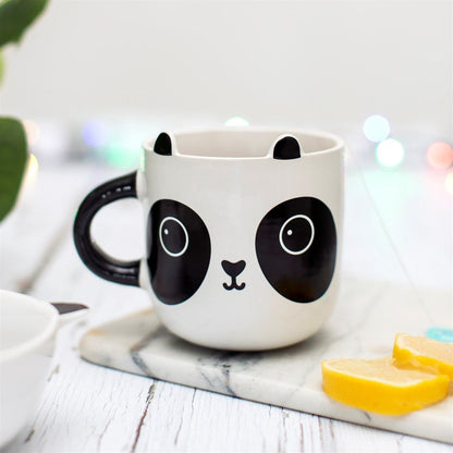 White panda bear mug on countertop with black ears and round eye designs; steam visible
