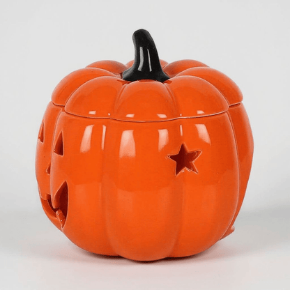 Orange jack-o-lantern oil burner with black stem, side face cutouts and star design