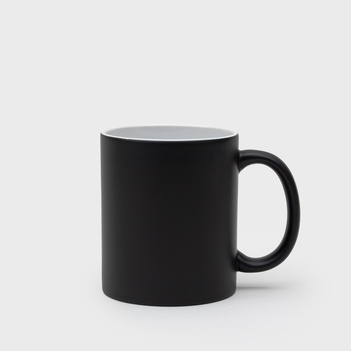 Plain black ceramic mug with white interior and right-side handle