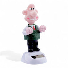 Solar-powered Wallace figurine with pink face, green sweater and black boots