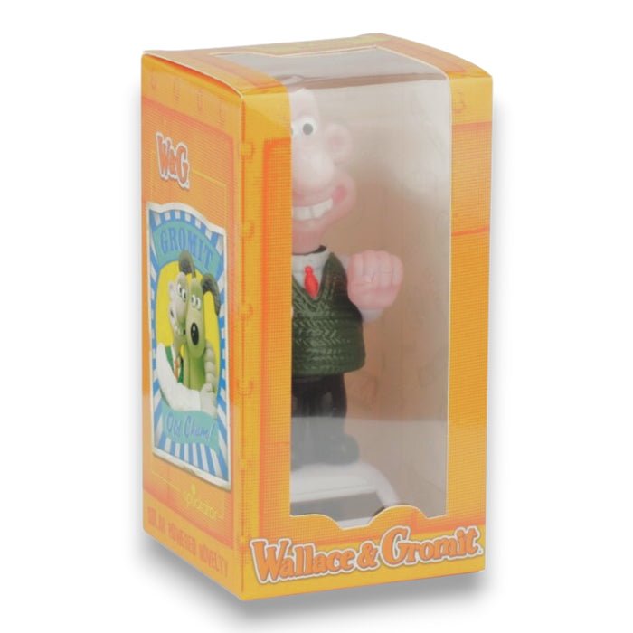 Solar-powered figurine in clear box, showing green sweater and raised arms