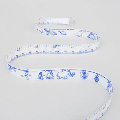 White measuring tape with blue dinosaur and vehicle graphics and metal loop end