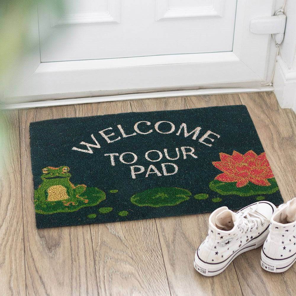 Dark green doormat with Welcome to Our Pad text and frog and lily pad design