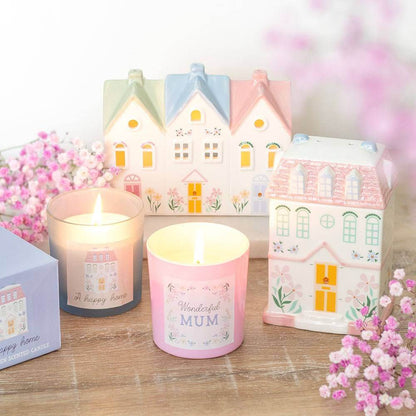 Pink scented candle with 'Wonderful Mum' label beside illustrated house-style gift boxes