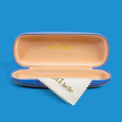 Open blue cat glasses case with beige interior and white triangle patch labeled “s s & belle”
