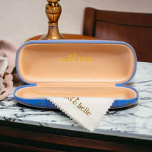 Open blue cat glasses case with beige lining and “sass & belle” logo on inside