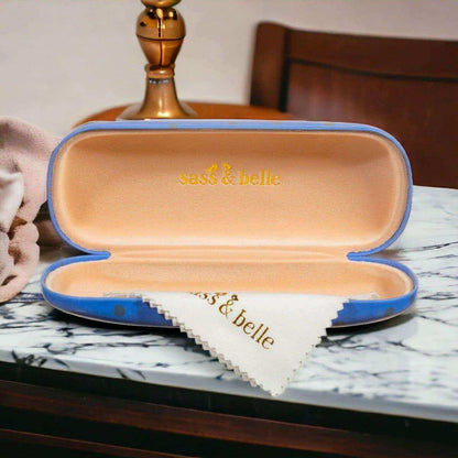 Open blue cat glasses case with beige lining and “sass & belle” logo on inside