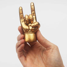 Gold rock-on hand ring holder held in a person’s palm